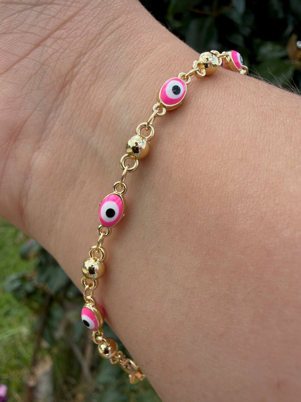 Pulsera ojito rosa. Laminado en oro 14k.