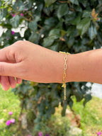 Pulsera cruz pedrería. Laminado en oro 14k.