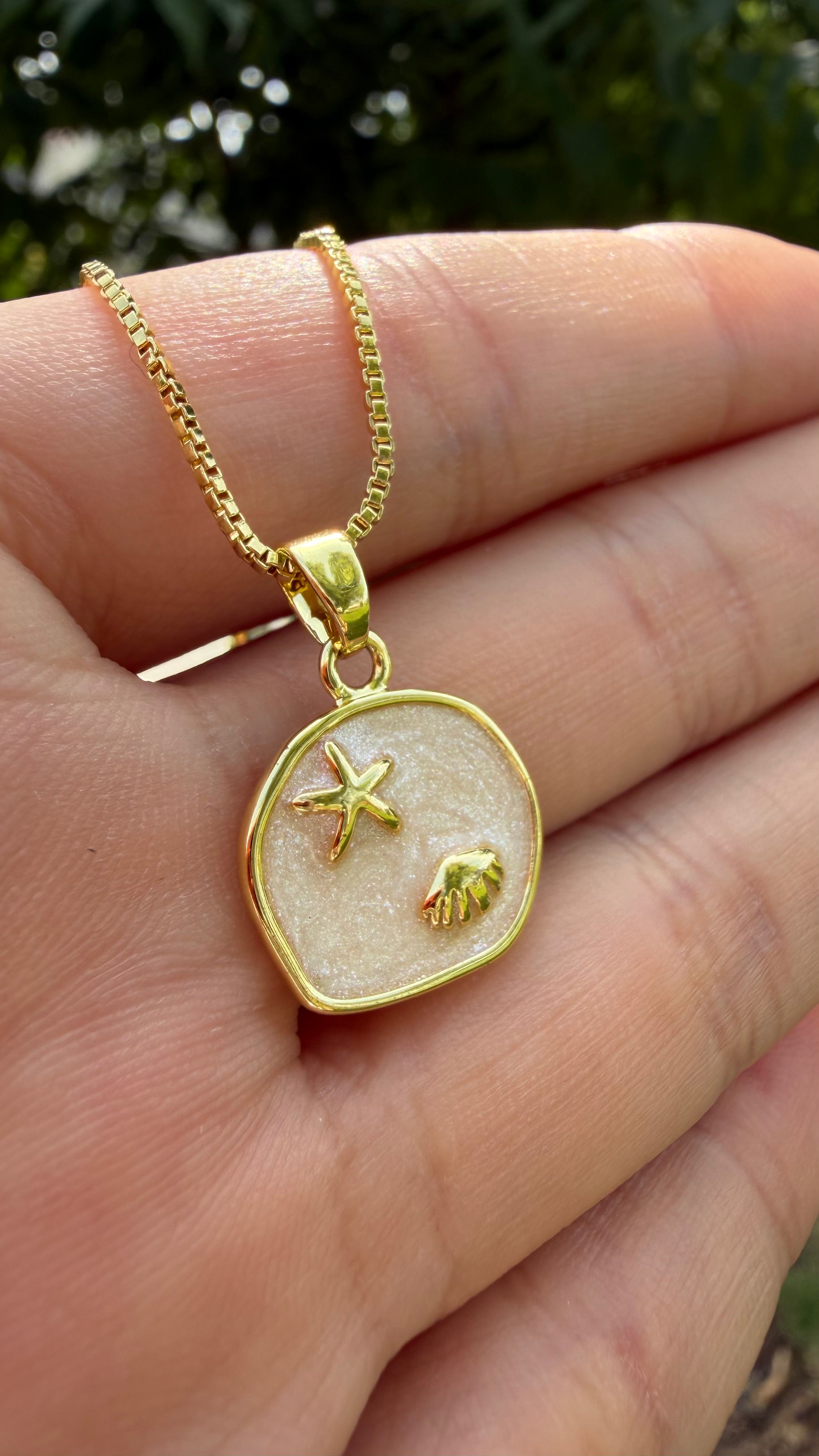 Collar marino estrellita + conchita (fondo glitter). Laminado en oro 14k